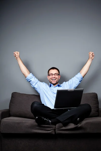 Empresario con portátil levanta brazos —  Fotos de Stock