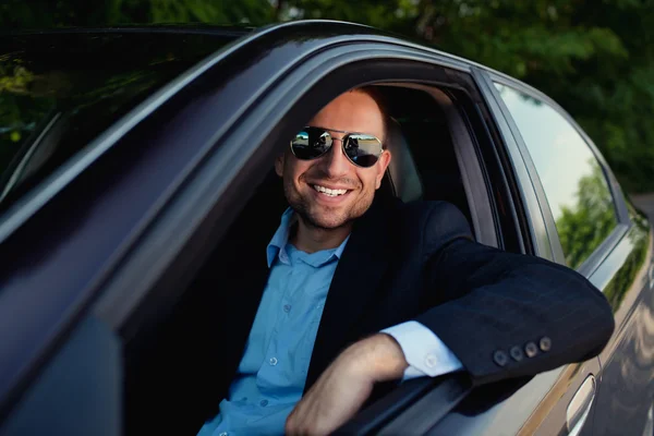 Businessman in car smiling — Stock Photo, Image