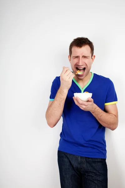 Молодой человек вынужден есть йогурт — стоковое фото