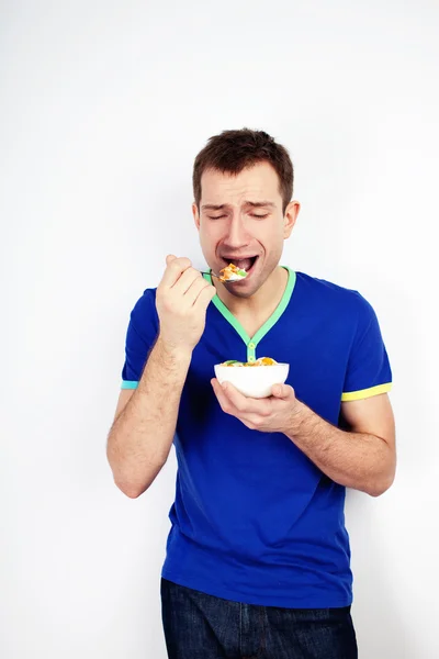 Mladý muž nuceni jíst jogurt — Stock fotografie