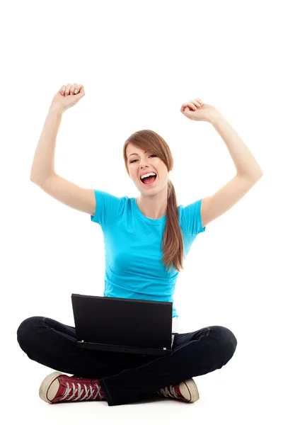 Female student with raised arms sitting with laptop — Stockfoto