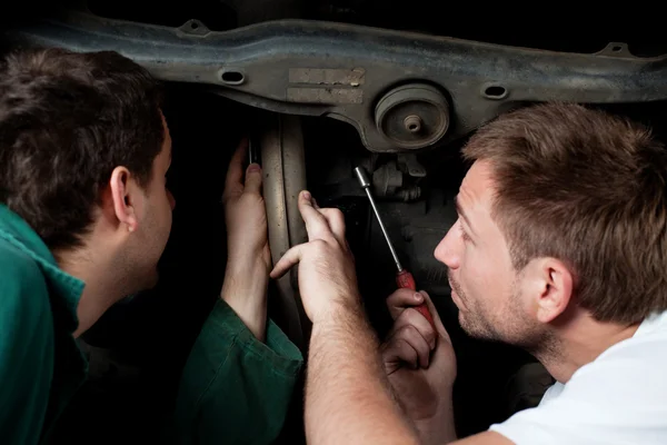 Dos mecánicos auto reparan el coche en servicio auto — Foto de Stock