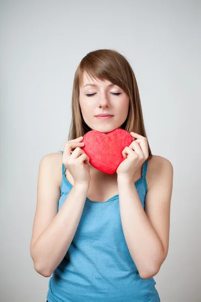 Kobieta wholding kształcie serca z zamkniętymi oczami — Zdjęcie stockowe