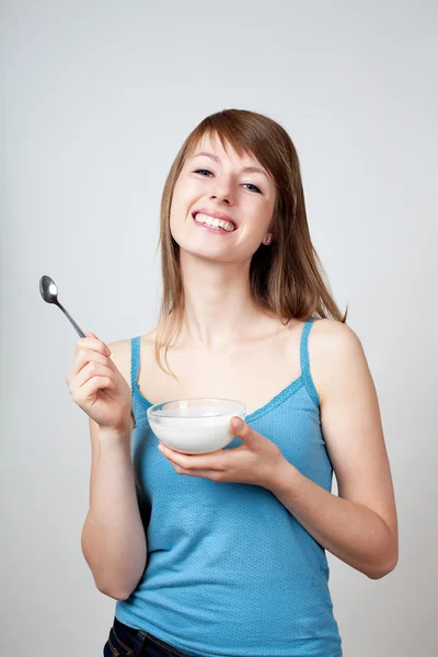 Mujer joven comiendo yogur — Foto de Stock