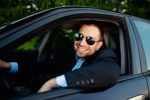 Hombre de negocios en coche sonriendo — Foto de Stock