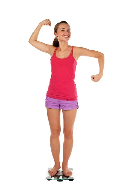 Junge Frau verspannt Muskeln auf Skala — Stockfoto