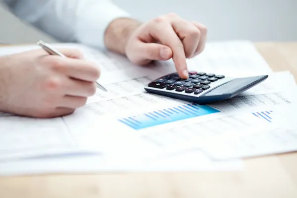 Financial data analyzing. Counting on calculator. — Stock Photo, Image