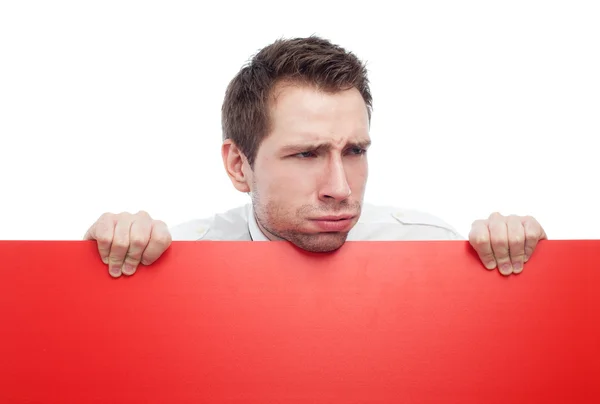 Young man holding red blank sigh sneering — Stock Photo, Image