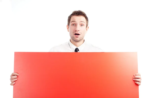 Ung affärsman med röd blank skylt förvånad — Stockfoto