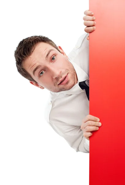 Curious businessman behind red billboard — Stock Photo, Image