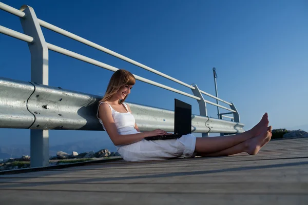 Schöne Frau mit Laptop im Urlaub — Stockfoto