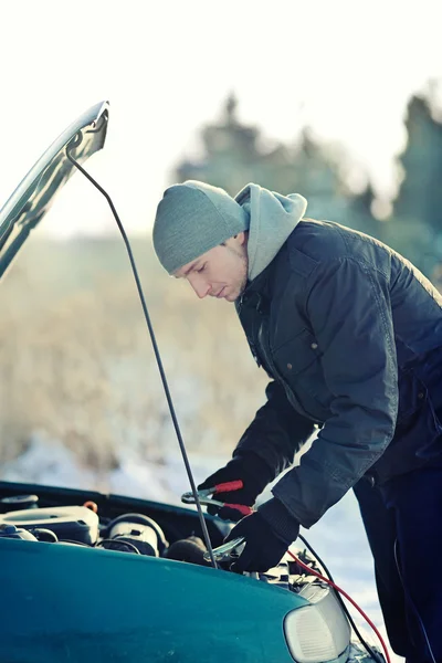 Hombre ayuda con coche roto con cable acumulador — Foto de Stock