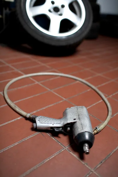 Pneumatiska hjul skiftnyckel på i garaget flor — Stockfoto