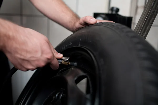 Mechanic deflating vehicle tyre closeup — Stock Photo, Image