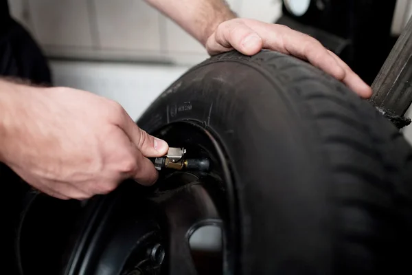 Mechanic deflating vehicle tyre closeup — Stock Photo, Image