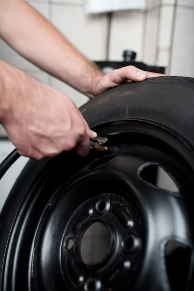 Ar de enchimento mecânico em um pneu de carro — Fotografia de Stock