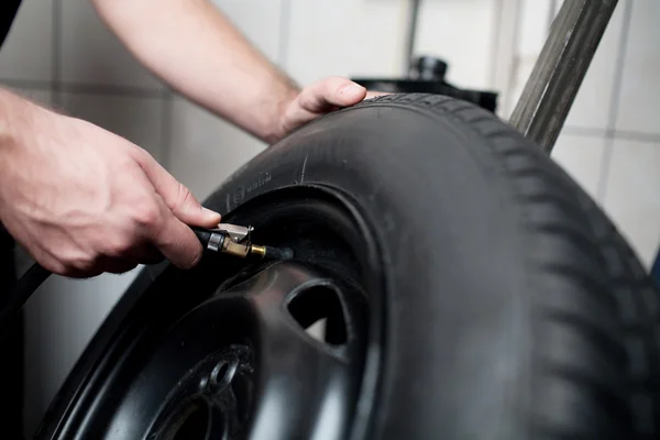 Mécanicien dégonflage pneu de véhicule gros plan — Photo