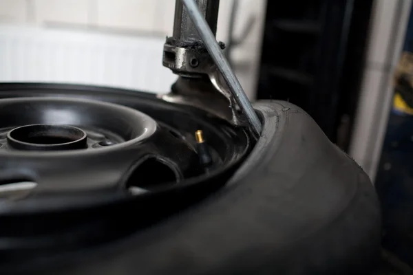 Mecânico mudando um carro pneu close-up — Fotografia de Stock