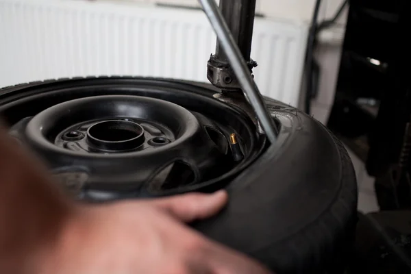 Mecânico mudando um carro pneu close-up — Fotografia de Stock