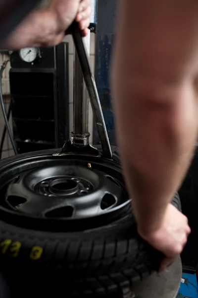 Mecánico cambiando el primer plano de un neumático de coche — Foto de Stock