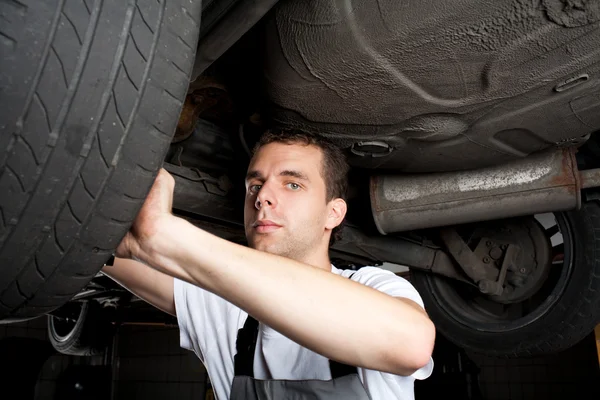 Closeup of mechanic working below car with wrench — Stock Photo, Image