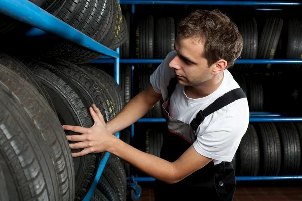 Auto mecânico escolhendo pneu no serviço de carro — Fotografia de Stock