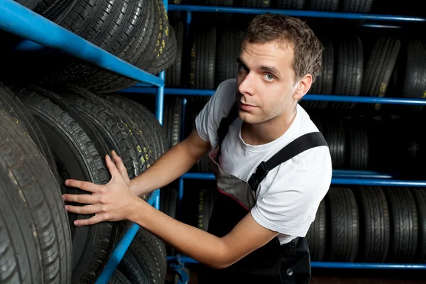 Auto mecânico escolhendo pneu no serviço de carro — Fotografia de Stock