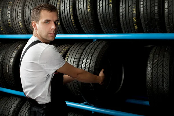 Car Mechanic holding a tire — Stock Photo, Image
