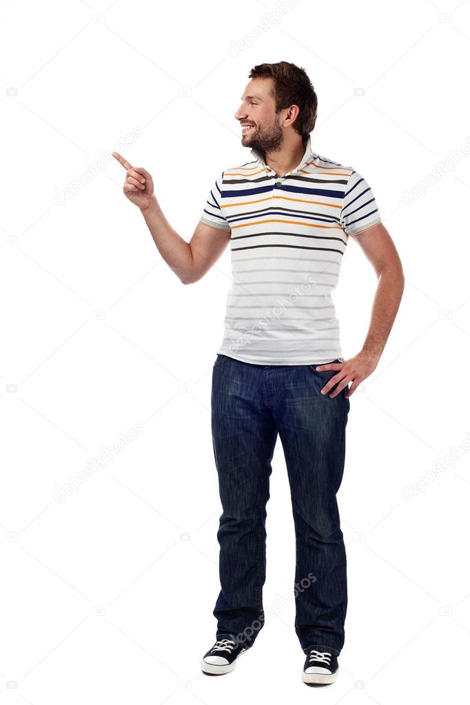 Young casual man pointing. Isolated