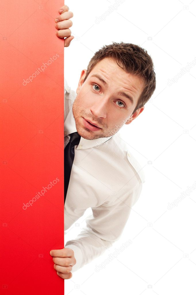 Curious businessman behind red billboard