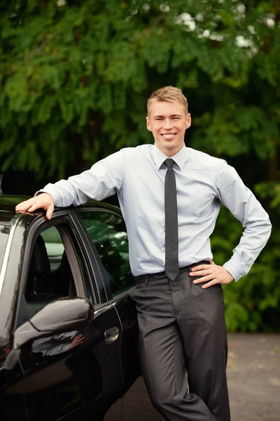 Бизнесмен, стоящий рядом со своей машиной — стоковое фото