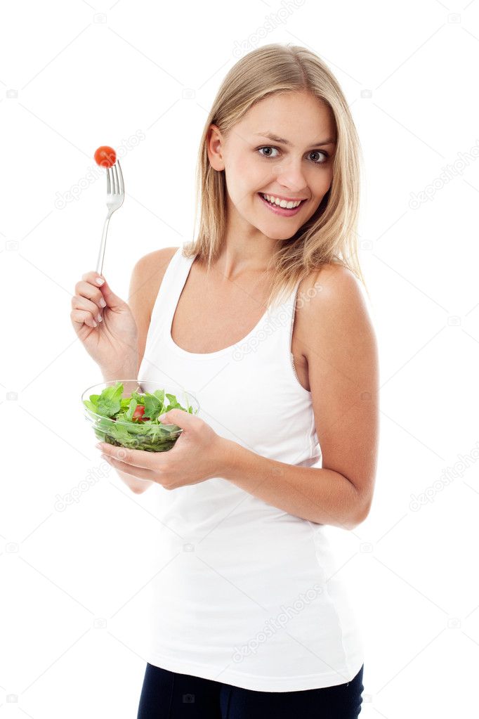Young woman eating salad. Isolated