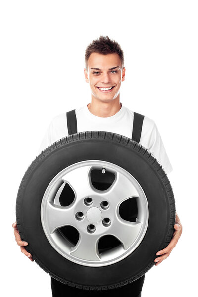 Auto mechanic holding car wheel