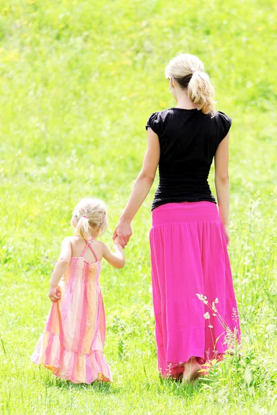 Een jonge moeder met haar dochter op het karakter — Stockfoto