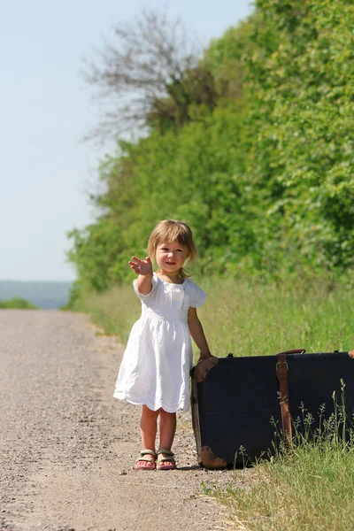 Güzel, küçük bir kız bavulla niteliğine — Stok fotoğraf