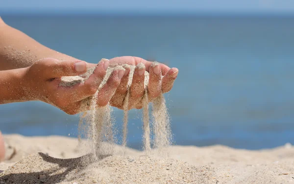 Hände schütten Sand aus — Stockfoto