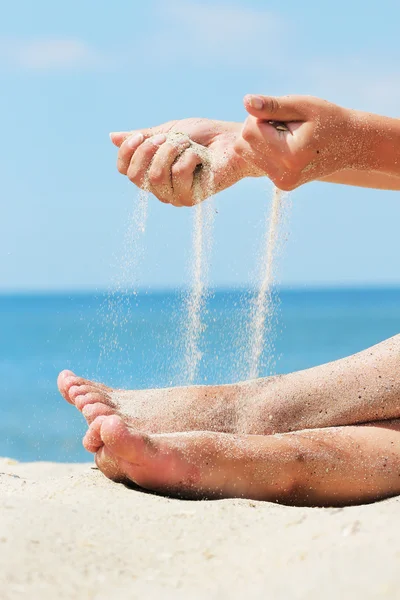 Руки льют песок — стоковое фото