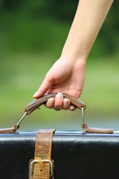 Mão com uma mala — Fotografia de Stock