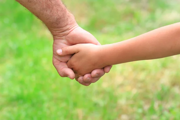 Vader geeft zijn hand aan een kind — Stockfoto