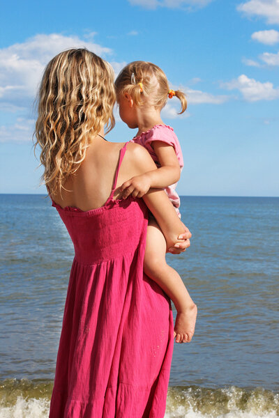 Mom with a child on the shore of the sea