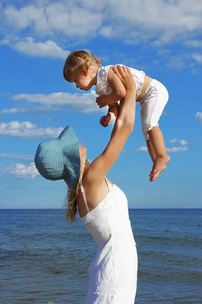 Mamma med ett barn på stranden vid havet — Stockfoto