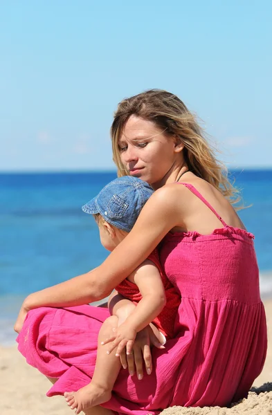 Mother with baby on the shore of the sea — Stock Photo, Image