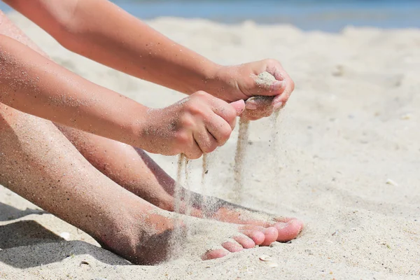 Mão derrama areia — Fotografia de Stock