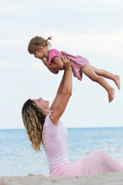 Una bambina con sua madre sulla riva del mare — Foto Stock