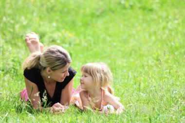 Young mother and her little daughter on the nature clipart