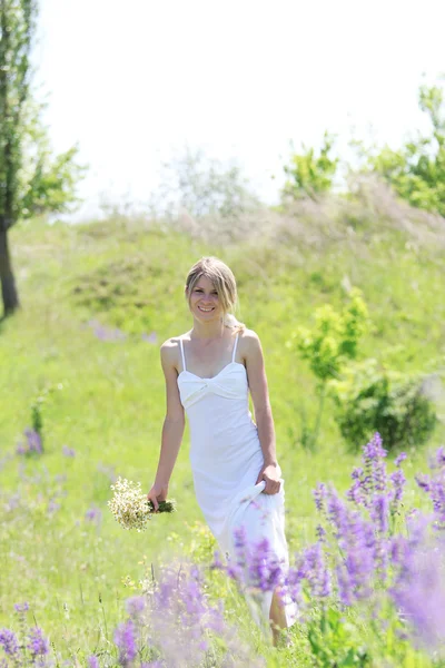 Ung kvinna med blommor i naturen — Stockfoto