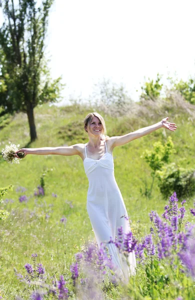 Junge Frau mit Blumen in der Natur — Stockfoto