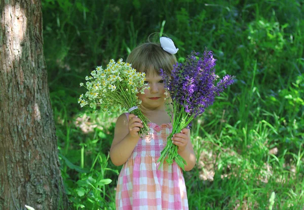 Маленькая девочка с цветами на открытом воздухе — стоковое фото