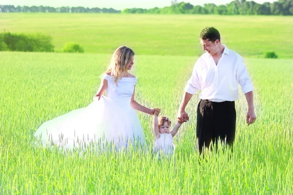 Par med en baby i ett fält av vete — Stockfoto