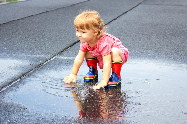 Een mooi klein meisje in de regen — Stockfoto